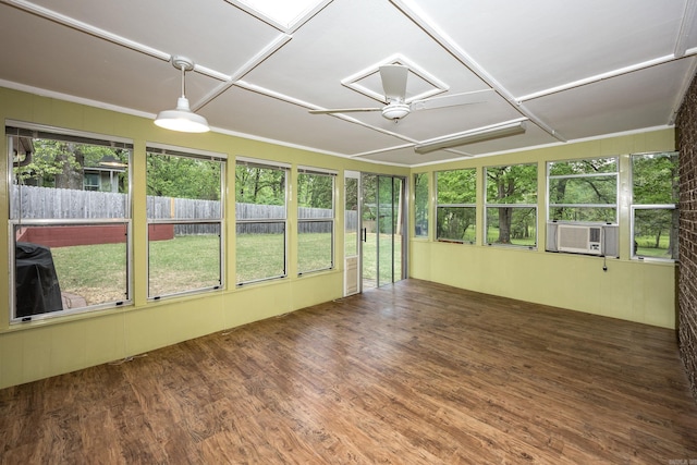 unfurnished sunroom featuring ceiling fan, wood finished floors, a wooden deck, and cooling unit