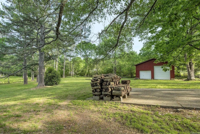 view of yard with a garage and an outbuilding