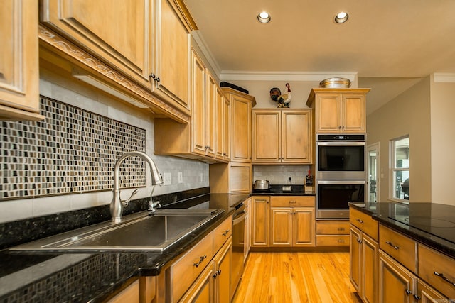 kitchen featuring tasteful backsplash, recessed lighting, light wood-style floors, appliances with stainless steel finishes, and a sink