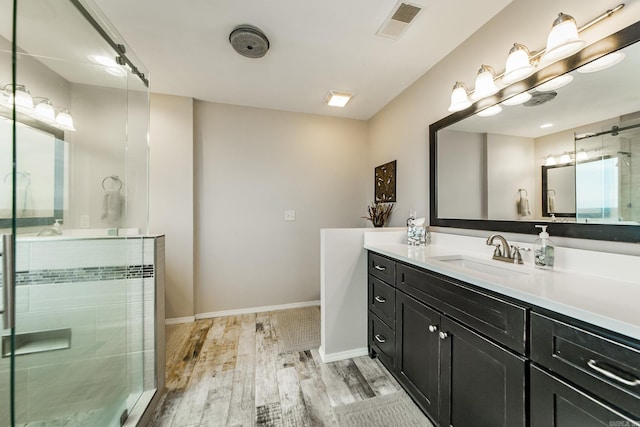 bathroom featuring wood finished floors, visible vents, vanity, and baseboards