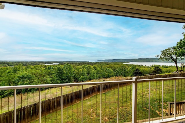 balcony with a wooded view and a water view