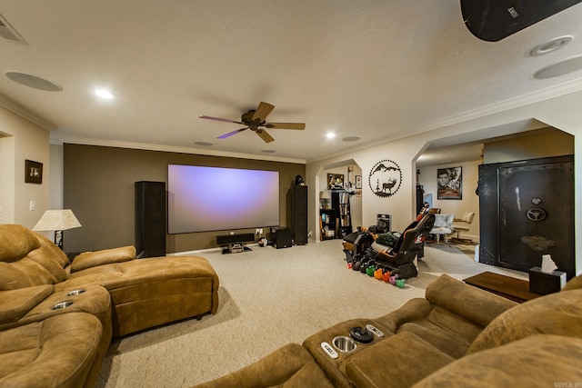 carpeted cinema featuring recessed lighting, crown molding, a ceiling fan, visible vents, and arched walkways