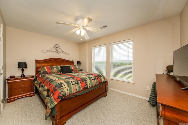 bedroom featuring baseboards, visible vents, ceiling fan, and light colored carpet