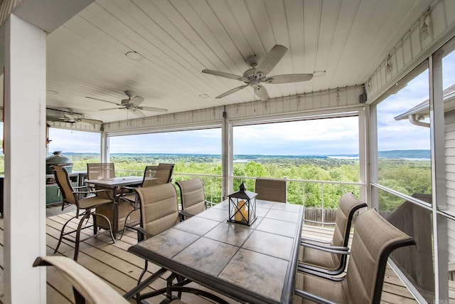 sunroom / solarium with outdoor dining area and a ceiling fan