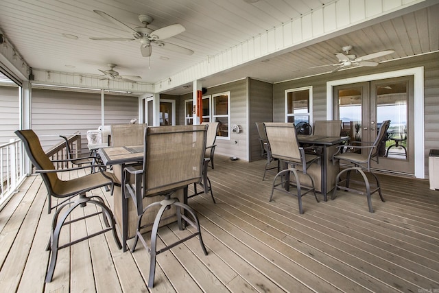 wooden terrace featuring outdoor dining space, ceiling fan, and french doors