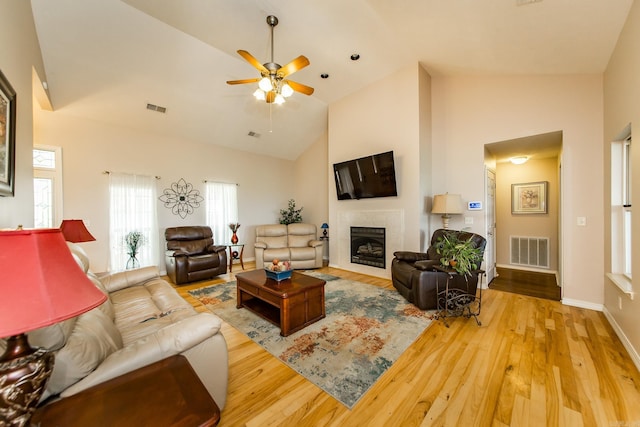 living area featuring visible vents, wood finished floors, a ceiling fan, and a fireplace
