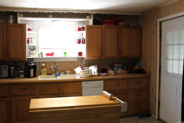 kitchen featuring a sink, wooden counters, open shelves, and white dishwasher