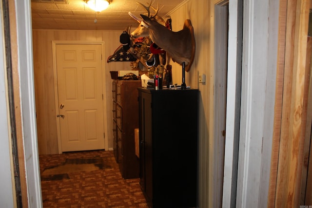 hallway featuring visible vents and wood walls