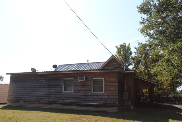view of side of home featuring metal roof and a lawn