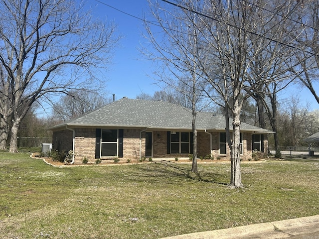 view of front facade featuring cooling unit, a front yard, fence, and brick siding