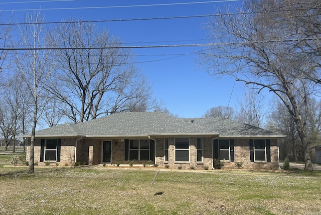single story home featuring a front lawn, a shingled roof, and brick siding