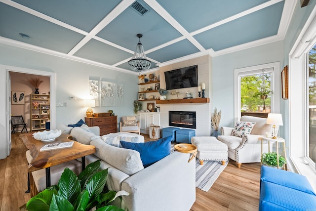 living area featuring visible vents, wood finished floors, coffered ceiling, and a fireplace