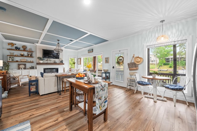 living room with a fireplace, light wood-style flooring, and coffered ceiling