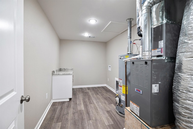 utility room with visible vents, heating unit, and water heater