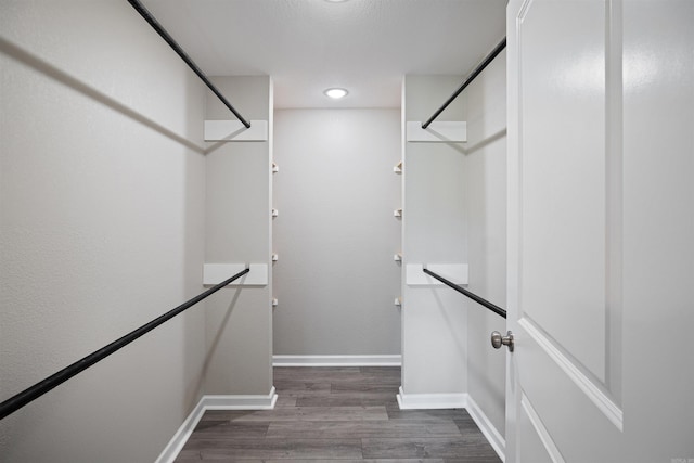 spacious closet with dark wood-style floors