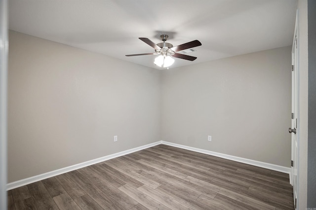 empty room with a ceiling fan, baseboards, and dark wood-type flooring