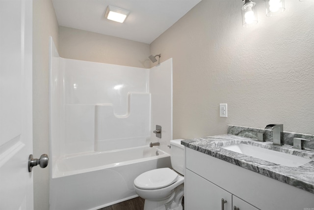 bathroom featuring wood finished floors, toilet, shower / bath combination, a textured wall, and vanity
