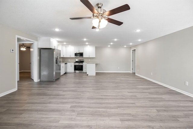 unfurnished living room with light wood-type flooring, a ceiling fan, recessed lighting, and baseboards