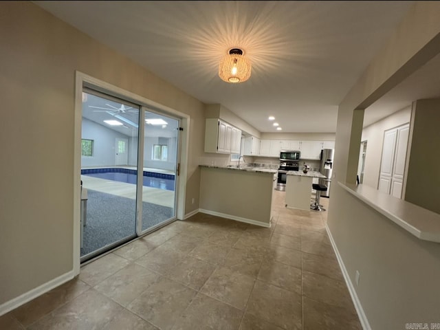 interior space featuring baseboards, a sink, and recessed lighting