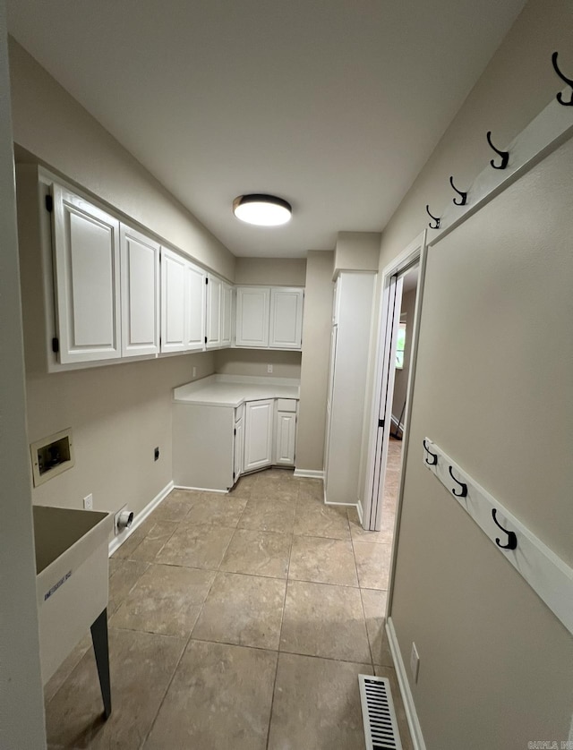 laundry area with visible vents, baseboards, hookup for a washing machine, cabinet space, and light tile patterned floors