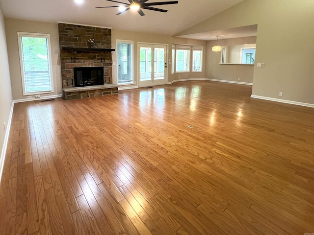 unfurnished living room featuring a ceiling fan, a fireplace, vaulted ceiling, wood finished floors, and baseboards
