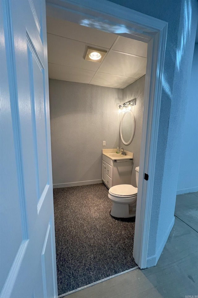 bathroom with toilet, baseboards, and vanity