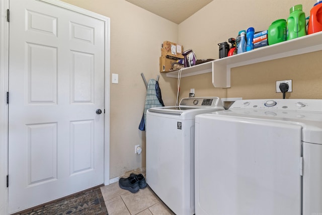 laundry room featuring washer and clothes dryer, baseboards, light tile patterned floors, and laundry area