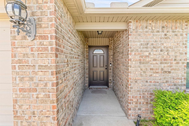 view of exterior entry with brick siding