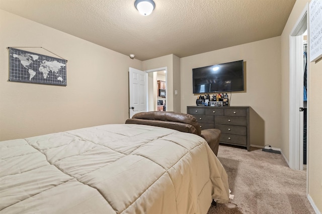bedroom with baseboards, a textured ceiling, and carpet