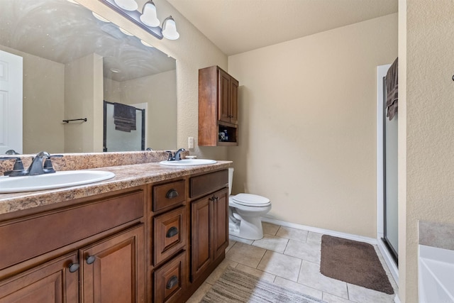 bathroom featuring a stall shower, double vanity, a sink, and tile patterned floors
