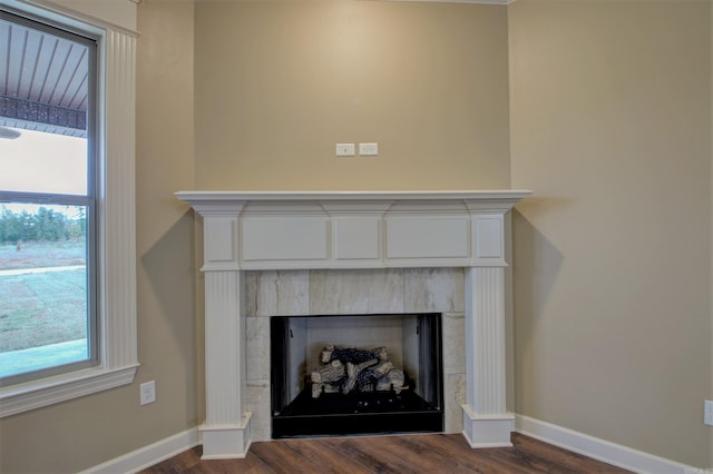 details with a tile fireplace, wood finished floors, and baseboards