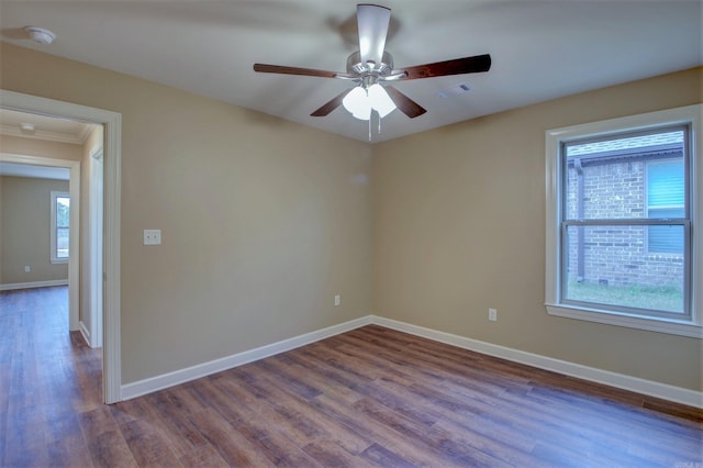 empty room with wood finished floors, visible vents, ceiling fan, and baseboards