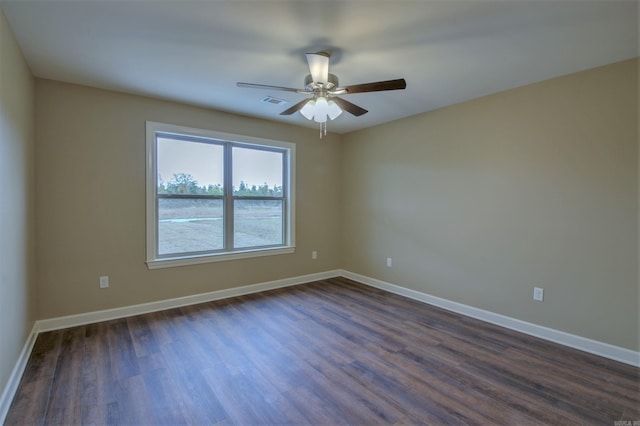 empty room featuring baseboards, visible vents, ceiling fan, and dark wood-type flooring