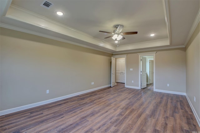 unfurnished bedroom with crown molding, a raised ceiling, visible vents, dark wood-style floors, and baseboards