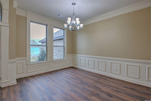 empty room featuring ornamental molding, dark wood-style flooring, a chandelier, and plenty of natural light