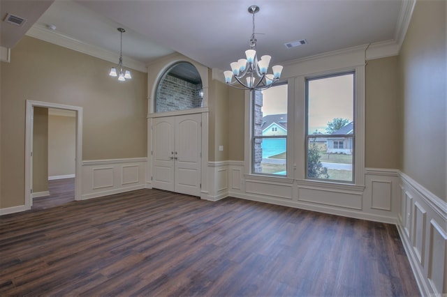 unfurnished dining area with a wainscoted wall, an inviting chandelier, dark wood-style flooring, and visible vents
