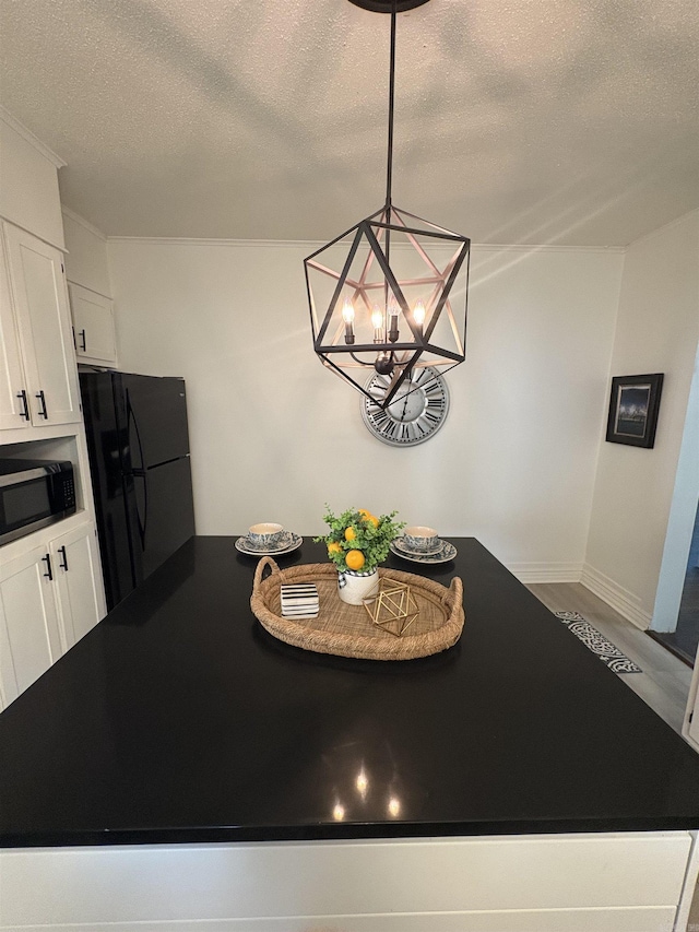 dining space featuring a chandelier, baseboards, ornamental molding, and a textured ceiling