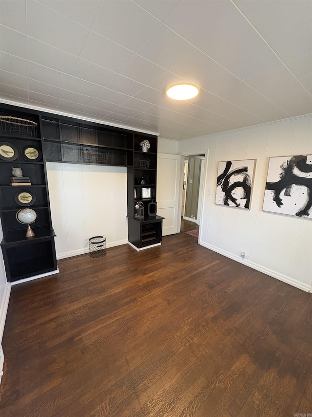 unfurnished living room featuring dark wood-style flooring and baseboards