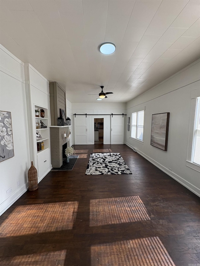living area featuring a brick fireplace, ceiling fan, wood finished floors, and baseboards