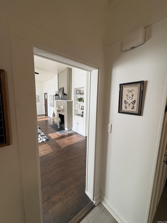 corridor featuring baseboards and wood finished floors
