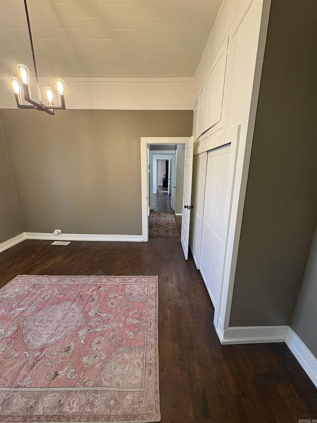 unfurnished dining area with baseboards and dark wood finished floors