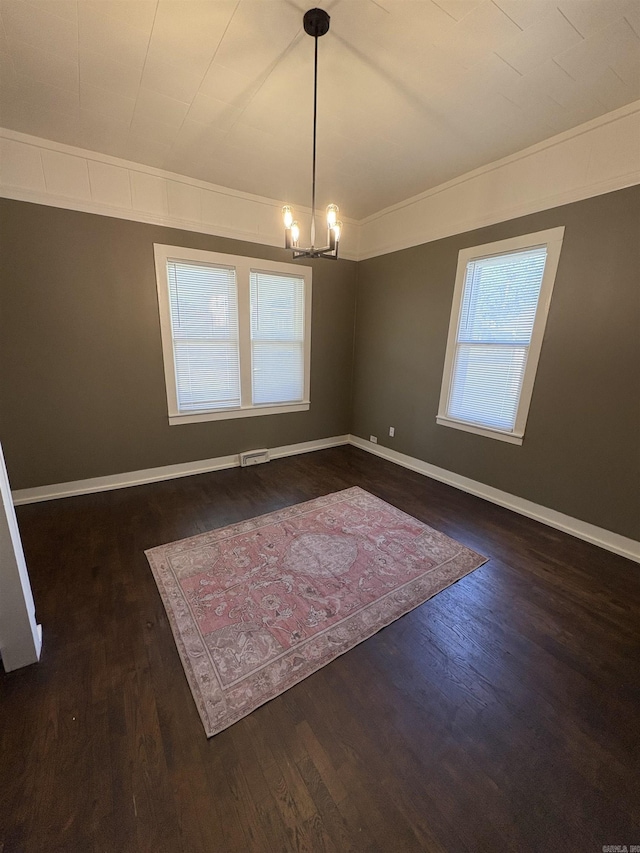 unfurnished dining area featuring visible vents, wood finished floors, a notable chandelier, and baseboards