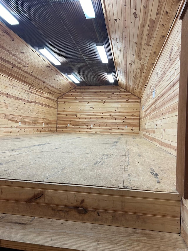 additional living space with wooden walls and lofted ceiling