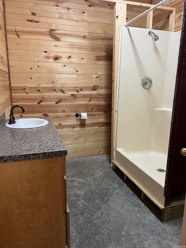 bathroom featuring a shower stall, wood walls, and vanity