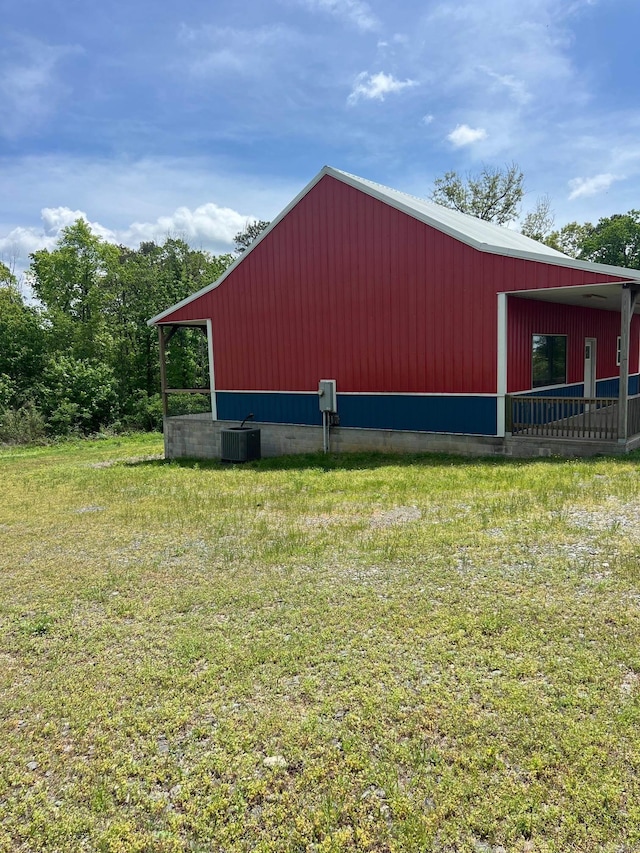 view of pole building featuring cooling unit and a lawn