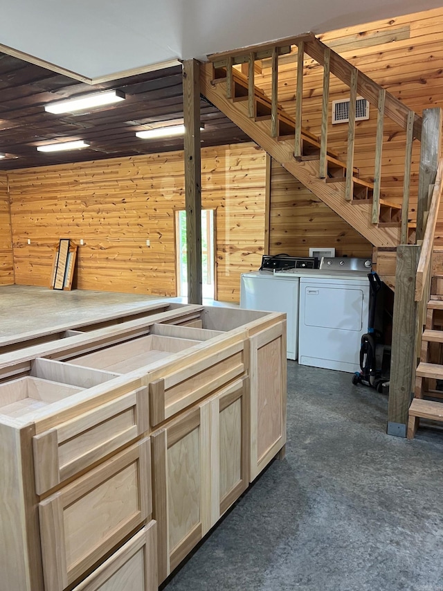 kitchen with washer and dryer, visible vents, wood walls, and dark colored carpet