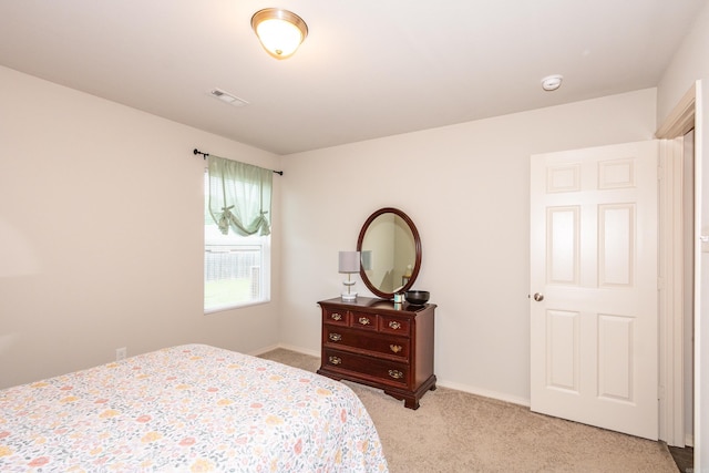 bedroom with light colored carpet, visible vents, and baseboards
