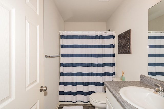bathroom featuring toilet, curtained shower, and vanity