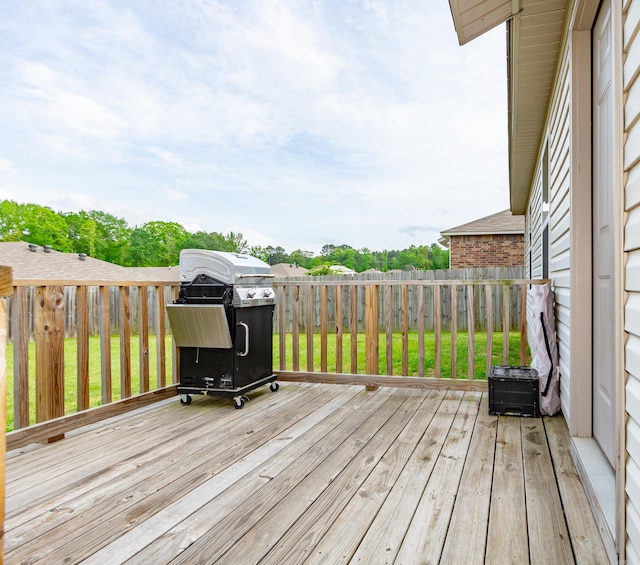 wooden terrace featuring grilling area and a fenced backyard