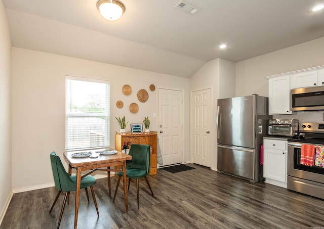 kitchen with white cabinets, visible vents, stainless steel appliances, baseboards, and dark wood-style flooring